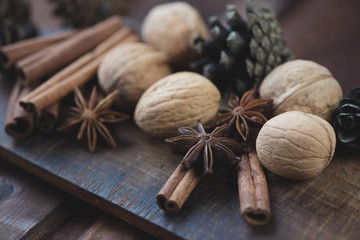 Anise, cinnamon sticks and walnuts, rustic wooden background