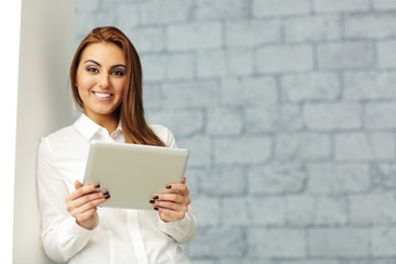 Young happy businesswoman with tablet computer in office