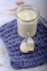 Aioli im Einmachglas auf gestrickter Unterlage