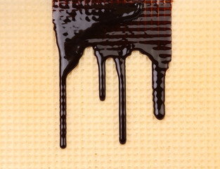 Stream chocolate on wafer. Close up.