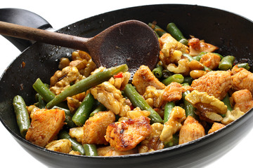 Green beans with chicken and walnuts in a frying pan