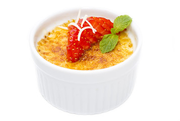 creme brulee garnished with strawberries on a white background