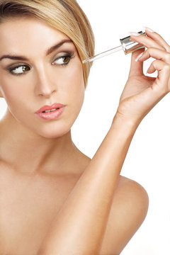 beautiful model applying a skin serum treatment