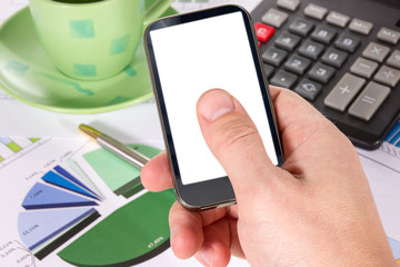 Hand with  phone against the background of office desk