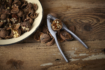 walnuts cracked open with old nut cracker in a vintage plate on