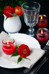 table setting with red buttercups on a black background