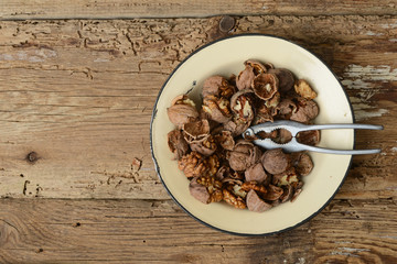 walnuts cracked open with old nut cracker in a vintage plate on