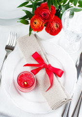 table setting with red flowers