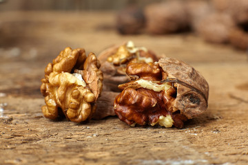 Close up of walnuts cracked open on a wooden table