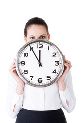 Business woman holding a clock in front of her face.