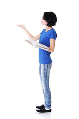 Attractive woman with workbook. Side view. Pointing on copy spac