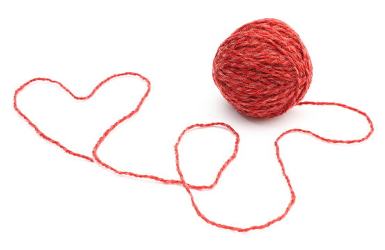 Heart shape and wool ball on white background