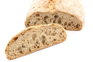 Slice of rye bread and loaf in background