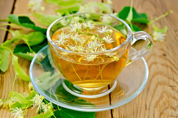 Herbal tea from linden flowers in a cup on the board