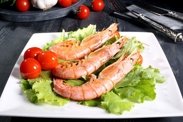 pesce gamberi alla griglia su insalata verde piatto bianco