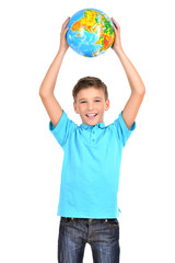 Smiling boy in casual  holding globe in hands above his head