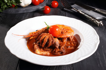 zuppa di pesce calamari e gamberi sfondo grigio