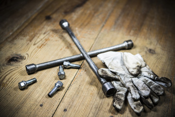 old used wrench with screw and dirty gloves