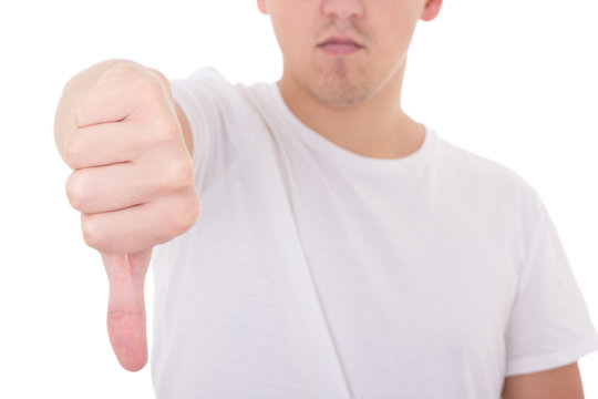 close up of young man showing thumbs down isolated on white