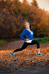 Young woman stretching before running in the early evening in th