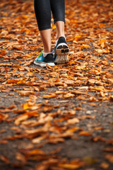 young woman running in the early evening autumn leaves