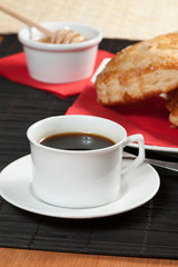 Breakfast including coffee, bread, honey.