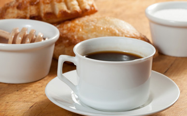 Breakfast including coffee, bread, honey.