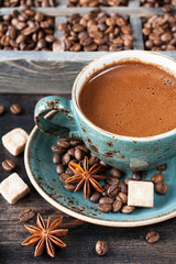 Cup of coffee with sugar and spices and a wooden box