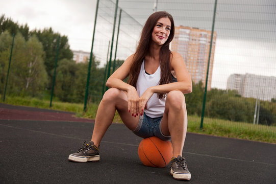 Sexy Woman Sitting On Basketball