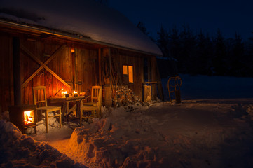 Fototapeta na wymiar Cozy wooden cottage in dark winter forest