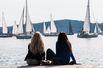 Two young woman looking at sailing boats