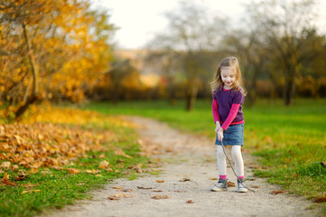 Adorable little girl having fun on autumn day