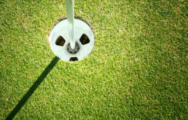 Obraz premium Golf cup on green background with copyspace