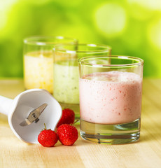 Fruit smoothie on wooden table on narural background