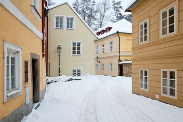 Empty street with old houses with fresh snow all around