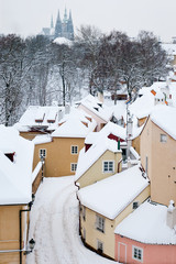 Quiet street with small houses in winter snow covered Prague