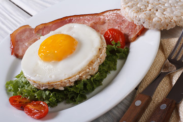 fried eggs with bacon and vegetables and rice bread.