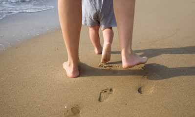 Mother and child walking on a sandy beach