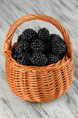 Fototapeta na wymiar Sweet blackberries in wicker basket on table close-up