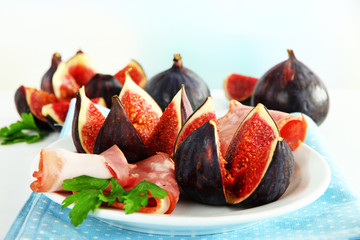 Tasty figs with ham on plate