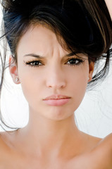 Naklejka premium Close up on girl frowning, looking unhappy and stressed.