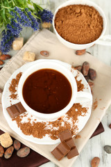 Cocoa powder in cup on napkin on wooden table
