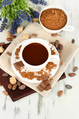 Cocoa powder in cup on napkin on wooden table