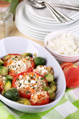 Stuffed tomatoes in bowl on wooden table close-up