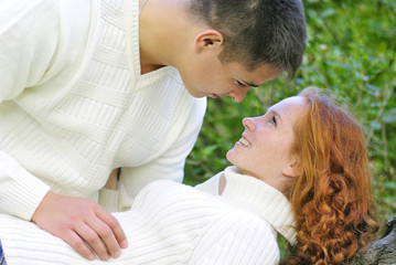 Fototapeta premium Young beautiful couple in the park in the white jerseys