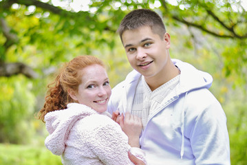 Obraz premium Young beautiful couple in the park in the white jerseys