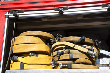 Rolled and yellow fire hoses on a fire truck