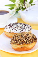 Sweet donuts with cup of tea on table close-up