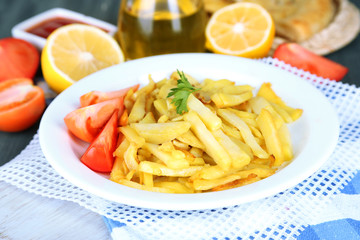 Ruddy fried potatoes on plate on wooden table close-up