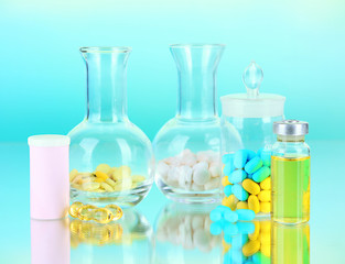 Medical bottles and pills on green background